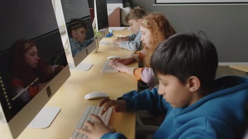 Alunos Escrevendo Código de Programação em Computadores Desktop em Sala de Aula