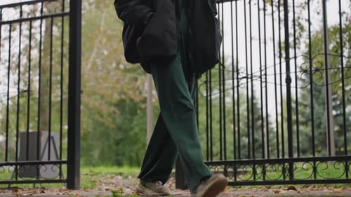 Pensive Woman in Evening Park with Backpack and Overcast Sky Casual Scene of Woman Standing Near