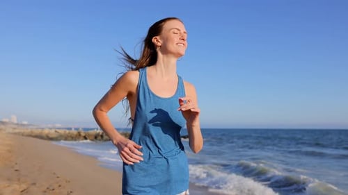 Woman Jogging on the Beach on a Sunny Day