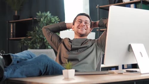 Man Relaxing At Desk in Office Environment