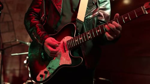 Musician Playing Electric Guitar on Stage at Night
