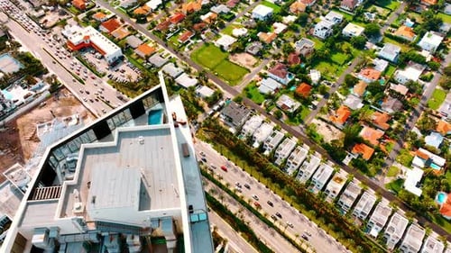 Footage above the top of the high-rise building with a swimming-pool and lounge area on.