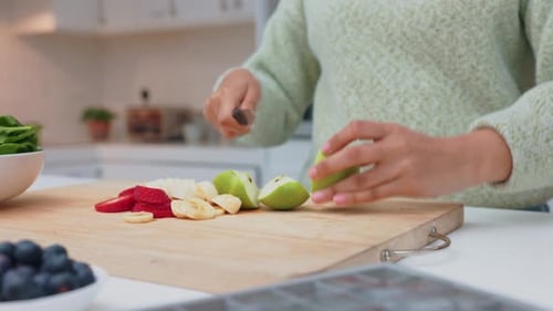 Woman Chopping Fruit on a Cutting Board