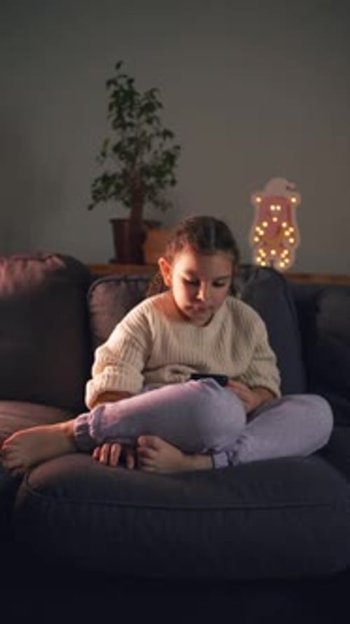 Girl Using Tablet on Couch at Night