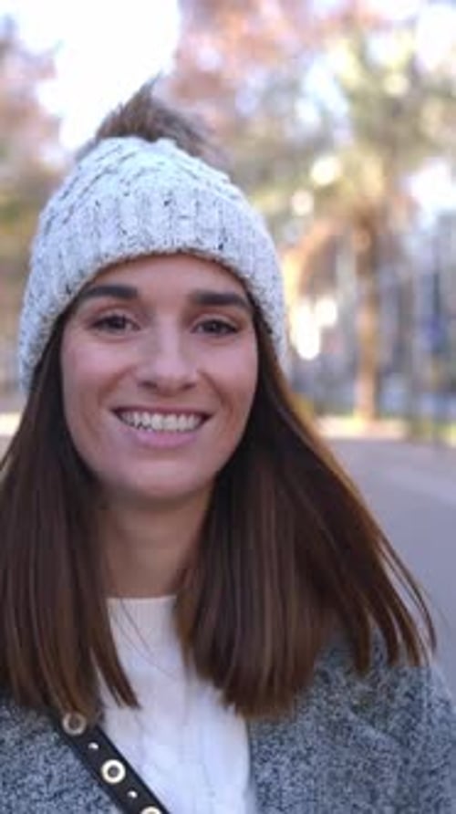 Young Woman Dressed in Winter Clothes Walking Towards the Camera at City Street