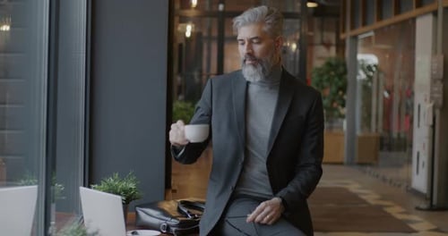 Mature Man Drinking Coffee in an Office