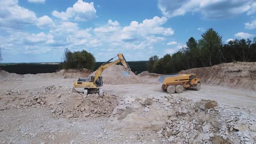 Excavator Fills Dump Truck at Stone Quarry