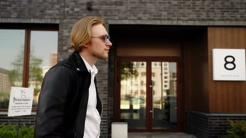 A Dreamer with Glasses Walks Along His House Lower Angle of Shooting Slow Motion Slavic Appearance
