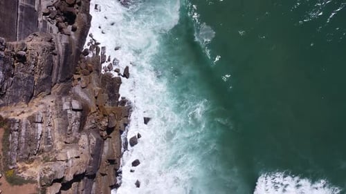 Aerial Drone View Of Turquoise Ocean Waves Crashing Against Rocks