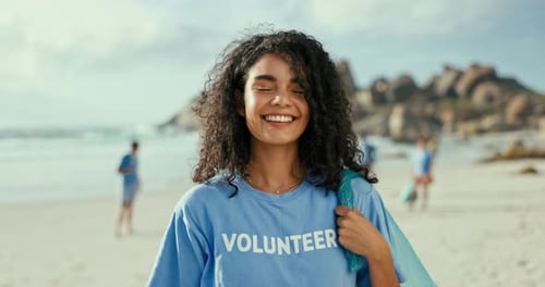 Portrait, volunteer and happy woman at beach with garbage bag for cleaning trash