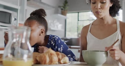 Woman and Child Enjoying Breakfast in Bright Kitchen