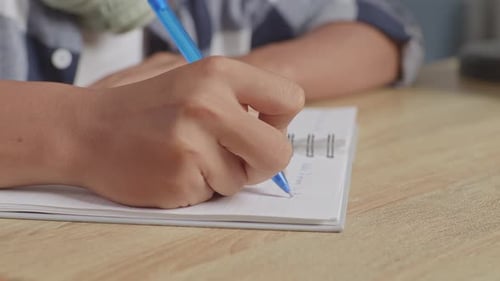 Close Up Teenager's Hand Writing On Paper
