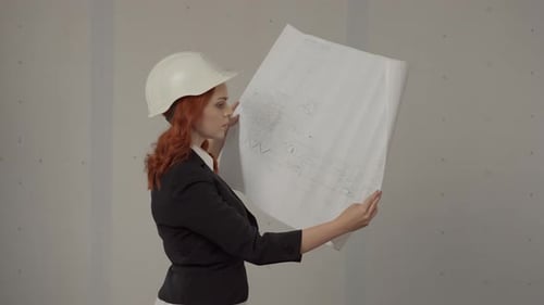 Side View of an Architect Woman Holding a Plan Drawing of a Building in Her Hands A Business Woman