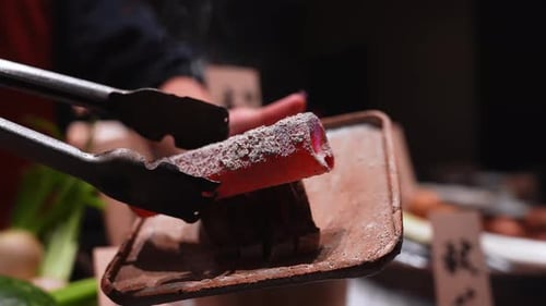 Primer plano de una brasa de carbón y una parrilla en un puesto de comida callejera de Tokio