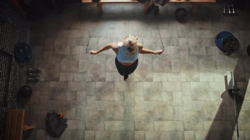 Athletic Beautiful Woman Wearing Sportswear Exercises with Skipping Rope in the Hardcore Gym. Fitne