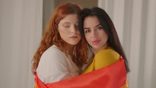 Affectionate Women Embracing with Rainbow Pride Flag