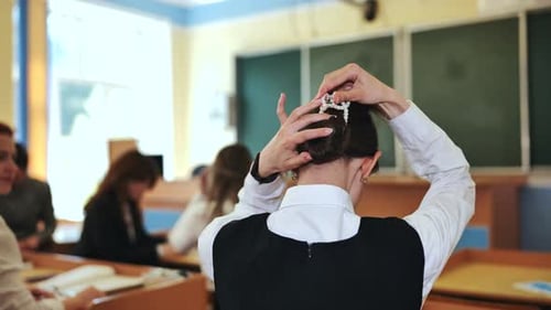Student Styling Hair with Pearl Clip in Classroom