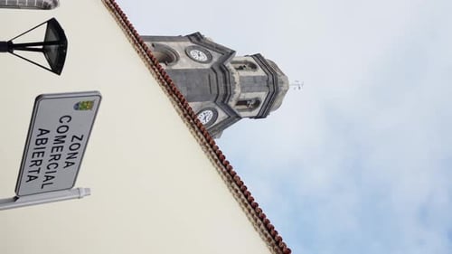 Ein hochstehender Glockenturm mit einer Glocke auf der Spitze vor einem strahlend blauen Himmel