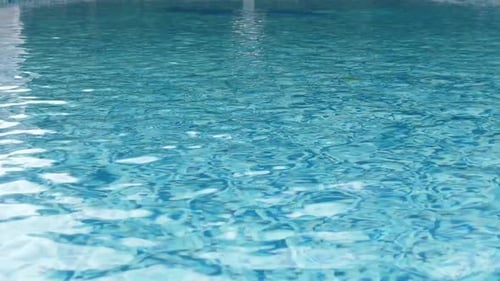 Clean Swimming Pool with Clear Blue Water and Sun Reflections