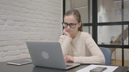 Woman Working on Laptop at Office Desk