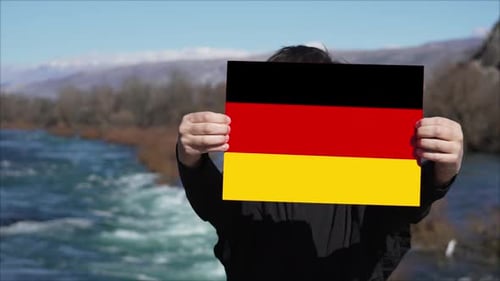 Person, die ein Banner mit der Flagge von Deutschland hält