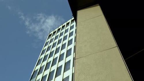 Abstract urban composition: skyscraper's reflective glass facade against a clear blue sky.