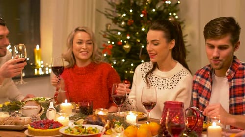 Friends Enjoy Christmas Dinner and Toast with Wine
