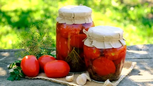 Canned Tomatoes and Fresh Vegetables on a Wood Table