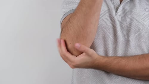 Man Rubbing Aching Elbow