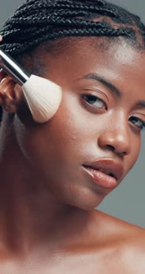 Face, black woman and makeup brush for beauty in studio for glow, foundation and aesthetic