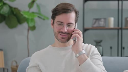 Man with Glasses Talking on Cellphone at Home