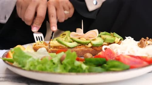 Woman Cuts and Eats Healthy Open Sandwich