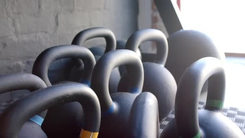 Kettlebells in various sizes resting on gym floor, ready for use