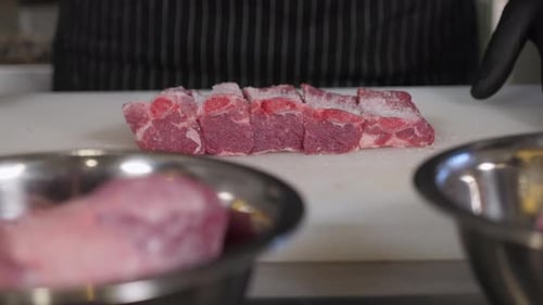 Closeup of the Chef Sprinkling Salt on Fresh Pork Ribs in the Restaurant Kitchen