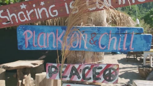 Bemalte Holzbeschilderung an einer geschlossenen Strandbar in Thailand