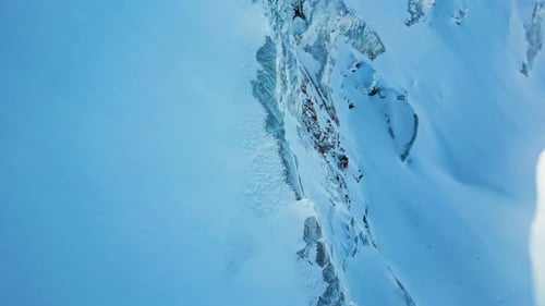 Lone Mountaineer Scaling Snowy Mountain Peak