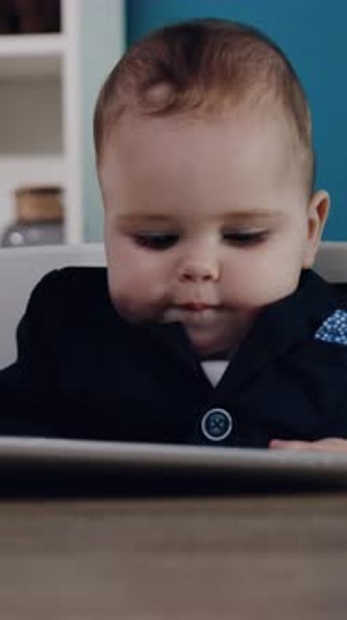 Infant Tapping on Tablet Device Wearing a Suit