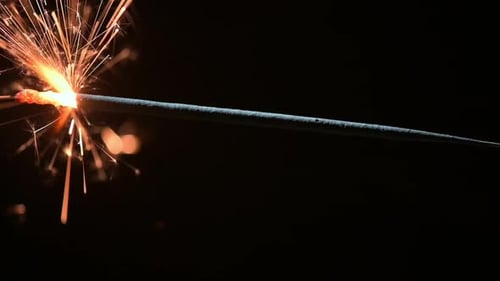 Burning Sparkler Emitting Golden Sparks in the Dark