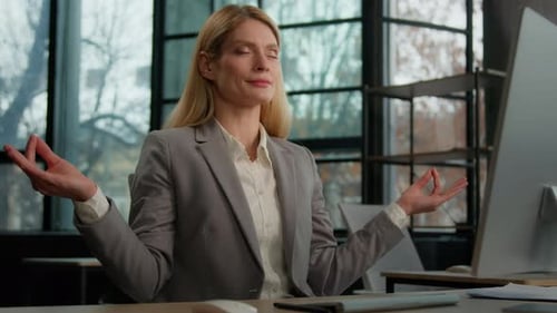 Woman Meditating at Her Office Desk