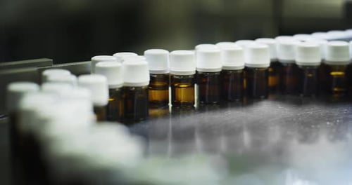 Gros plan de la production de médicaments dans des flacons de verrerie sur des lignes automatiques dans une usine pharmaceutique