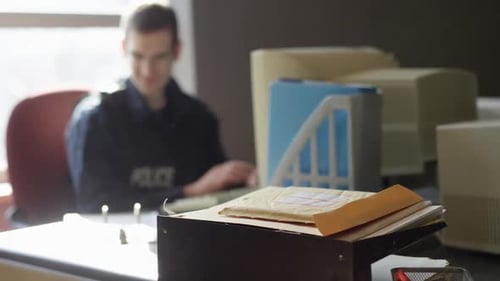 Police Officer Reviews Paperwork and Types