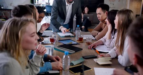 Teamwork Concept Young Caucasian Boss Leading Multiethinc Team Discussion at Trendy Office Using