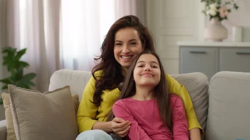 Smiling Mother and Child Bonding on Sofa