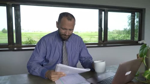 Junger Geschäftsmann genießt Kaffee und liest zu Hause eine Zeitschrift