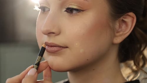 A Makeup Artist Blends Foundation and Gently Works on the Young Woman Skin
