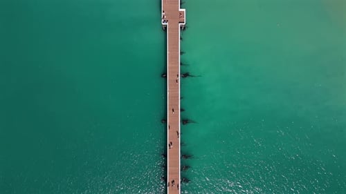 Experience the Stunning Aerial Views of a Scenic Pier Nestled Over Beautiful Turquoise Waters