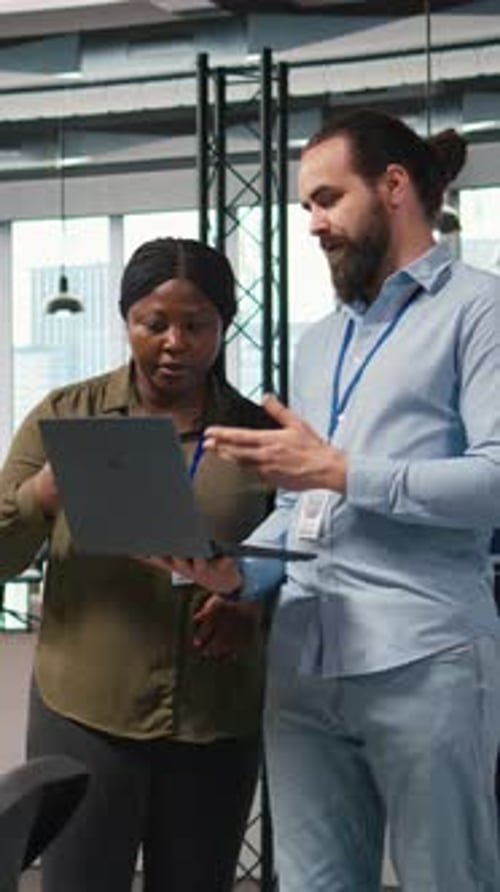 Vertical Video Teamworking Programmers in Office Reviewing AI System Metrics