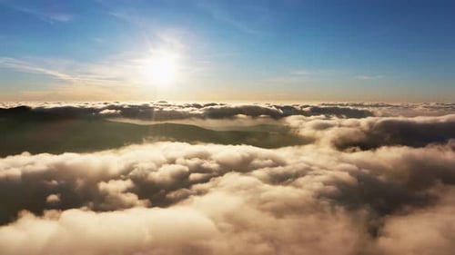 Soleil brillant au-dessus des nuages blancs duveteux au lever du soleil