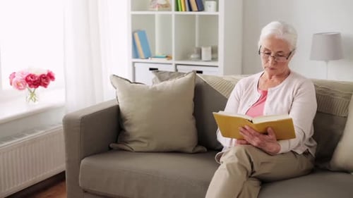 Age, Vision And People Concept - Senior Woman In Glasses Reading Book At Home