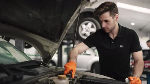 Mechanic Inspecting Car Engine in Auto Repair Shop